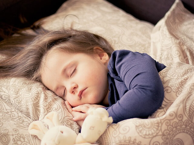 Dziecko śpi w beżowo-złotej pościeli