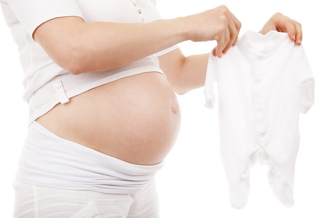 Kobieta w ciąży ze śpioszkami